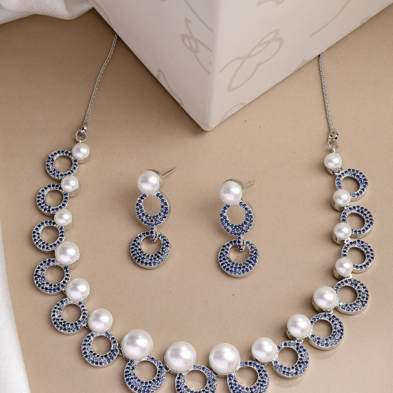 Sukkhi Eye Catchy Rhodium Plated with Cubic Zirconia & Pearl Studded Blue Round Brass Collar Necklace with Drop Earrings Jewellery Set for Women