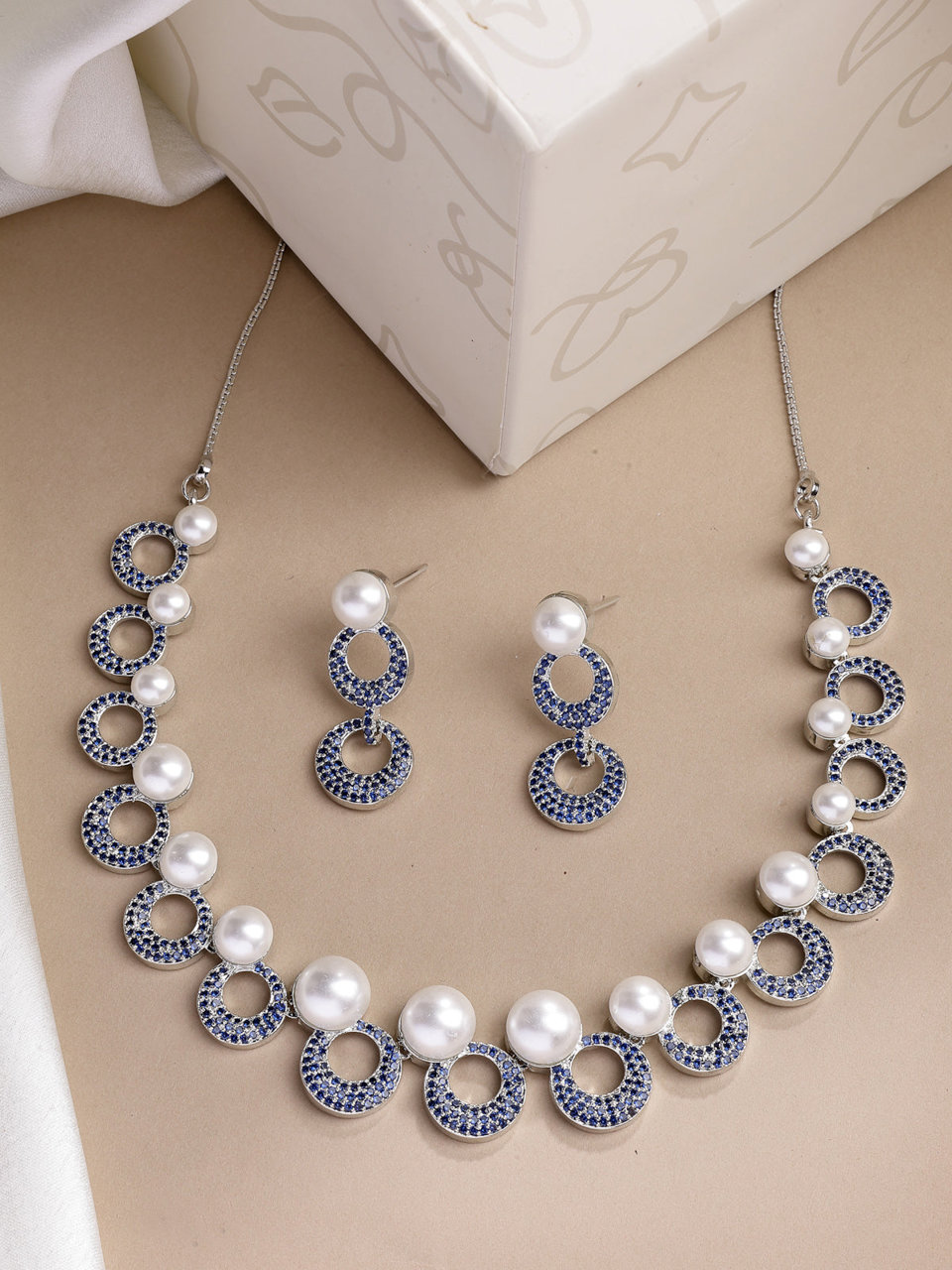 Sukkhi Eye Catchy Rhodium Plated with Cubic Zirconia & Pearl Studded Blue Round Brass Collar Necklace with Drop Earrings Jewellery Set for Women